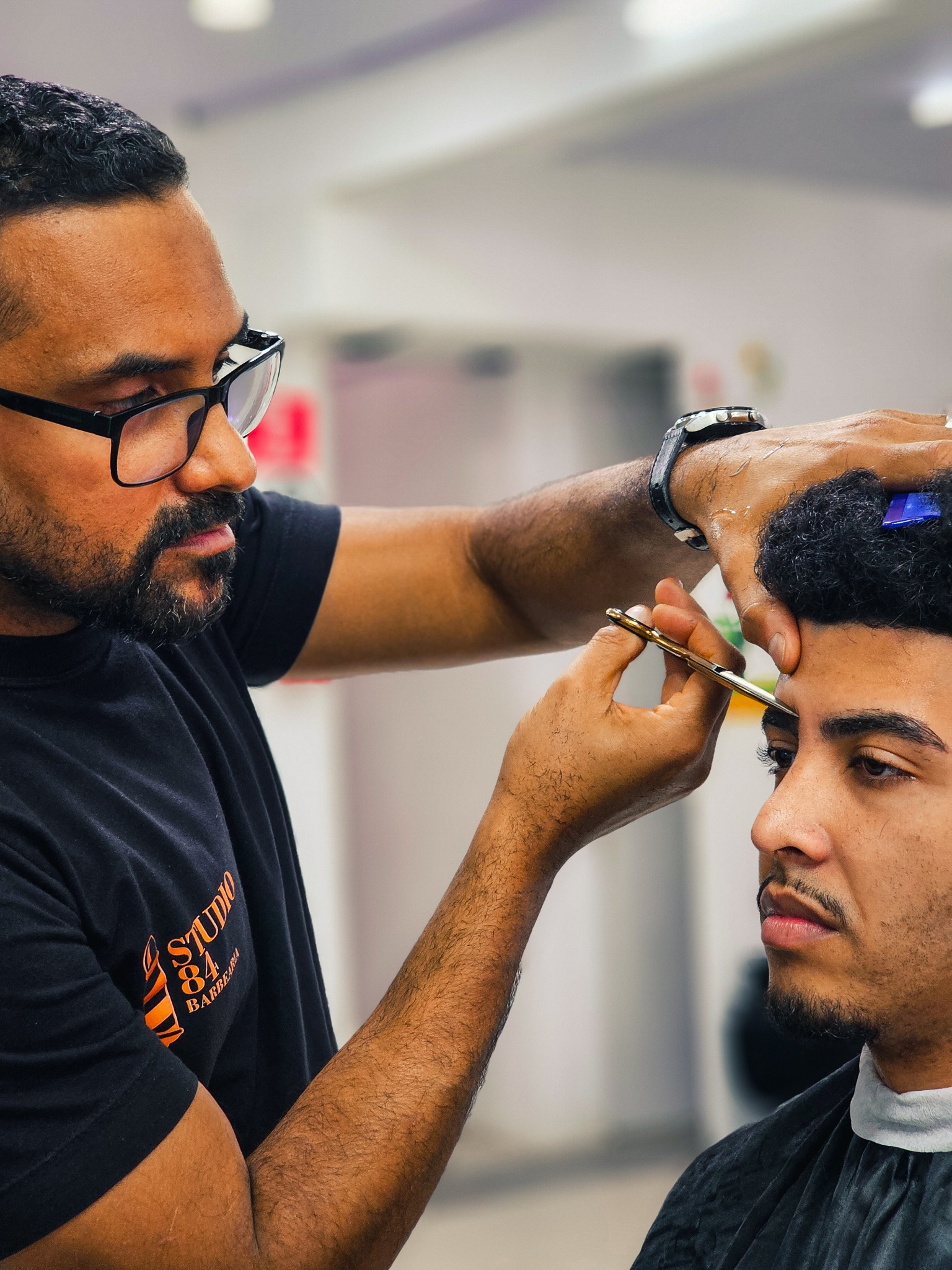 Barbeiro do Studio 84 realizando um corte