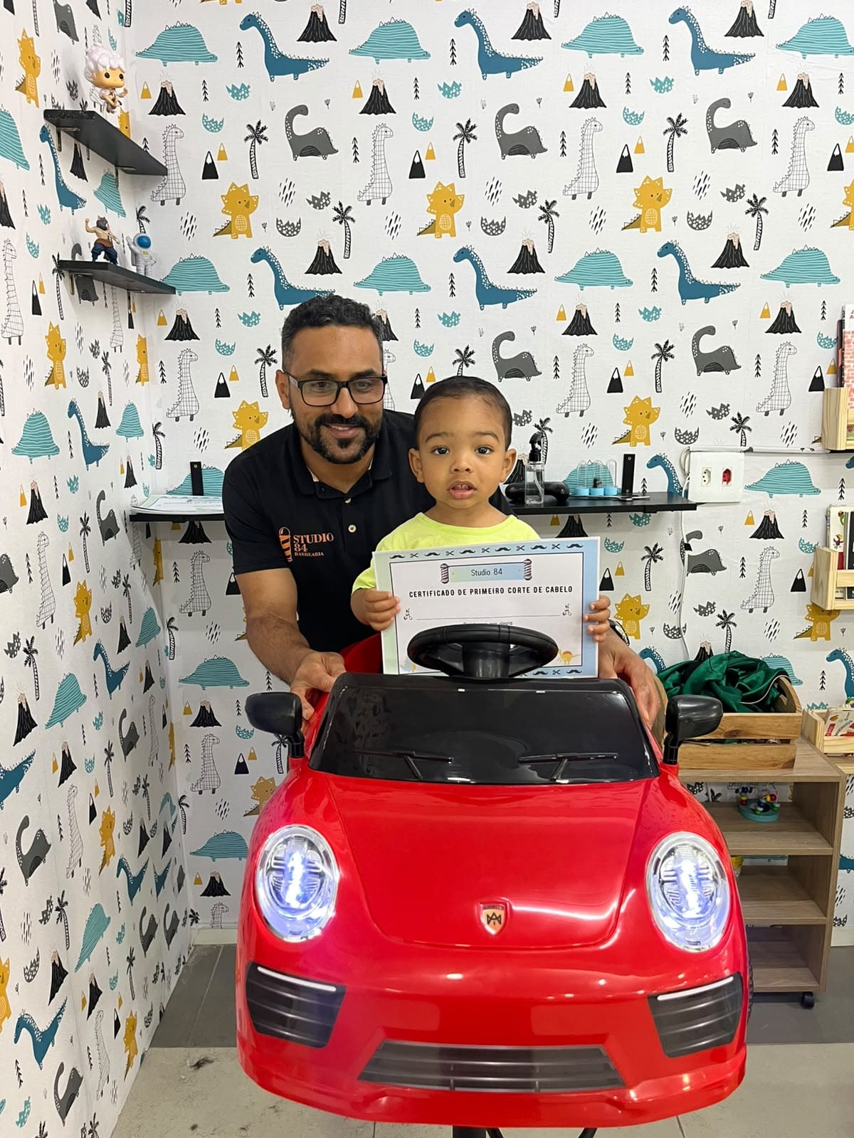 Criança com certificado de primeiro corte no espaço kids do Studio 84